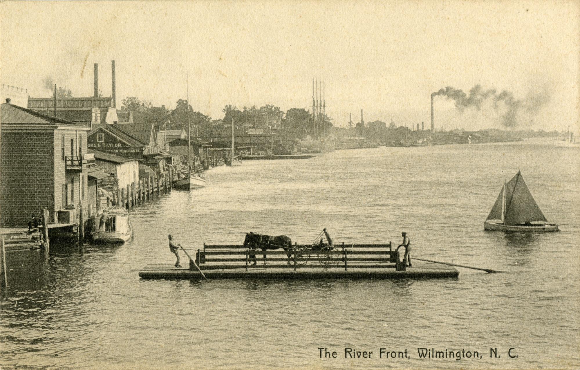 Historic ferry flat carrying passengers, a horse, and a vehicle across the Cape Fear River