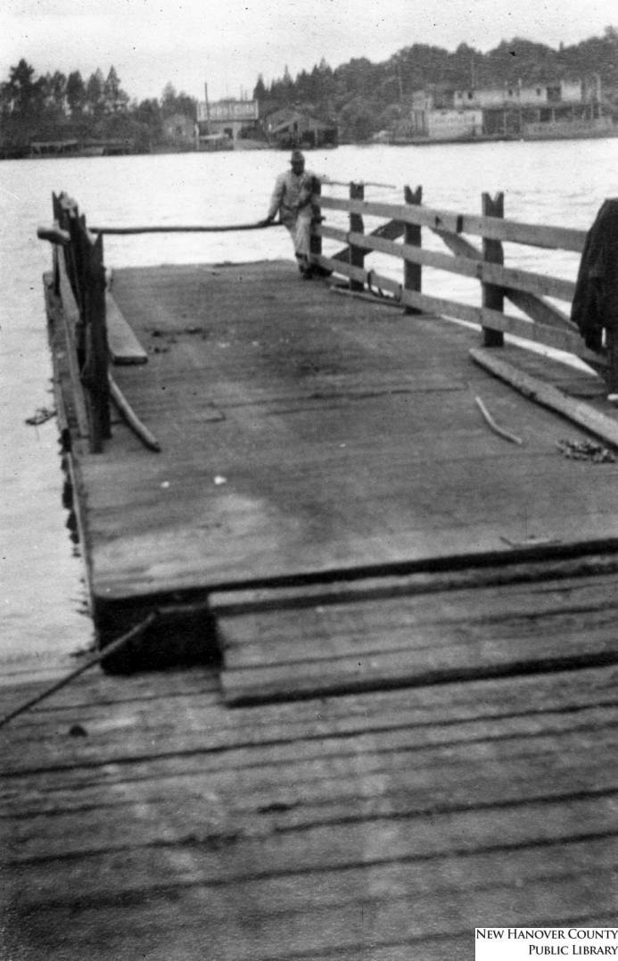 Historic photograph looking along the wooden deck of the Market Street ferry slip toward Eagles Island